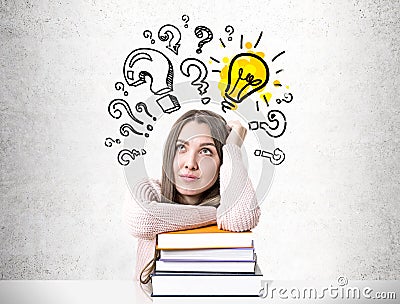 Dreamy student with a pile of books, bulb question Stock Photo