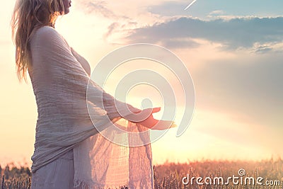 Dreamy woman holding the sun in her hands Stock Photo