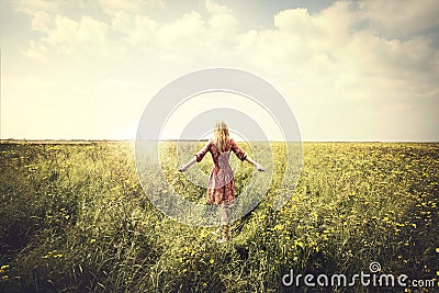 Dreamy woman walking in nature towards the sun Stock Photo