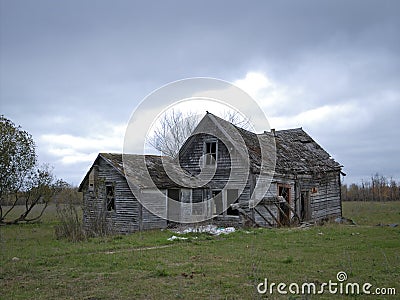 Dreary Abandoned Dilapidated Farm House with cloudy skies Stock Photo