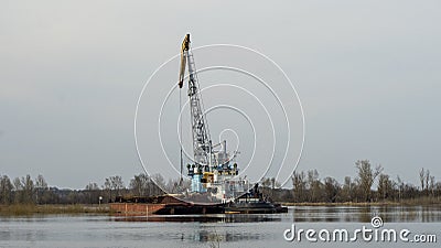 Dredger is working to deepen the fairway on the river. Cleaning and deepening by a dredger on the river. Stock Photo