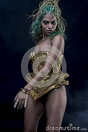 Dress, Latin woman with green hair and gold costume with handmade flourishes, fantasy image and tale Stock Photo