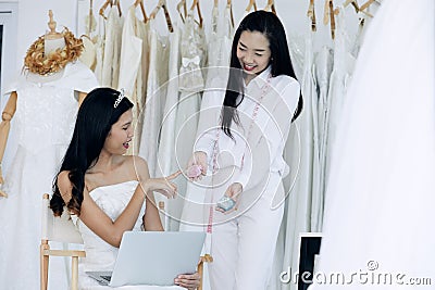 Dress maker show the souvenir boxes to bride Stock Photo