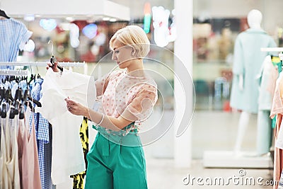 This dress is perfect Rear view of beautiful young woman trying on dress and looking at her reflection in the mirror Stock Photo