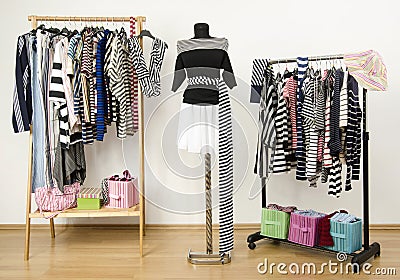 Dressing closet with striped clothes arranged on hangers. Stock Photo