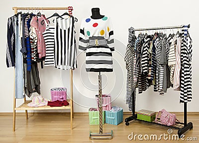 Dressing closet with striped clothes arranged on hangers. Stock Photo