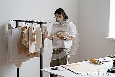 Dressmaker woman hold pattern for clothes in atelier. Fashion designer inspiring for work in studio Stock Photo