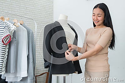 Dressmaker measuring a women suit and dress Stock Photo