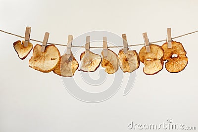 Dried apple slices hanging on a jute twine with wooden clothespins Stock Photo