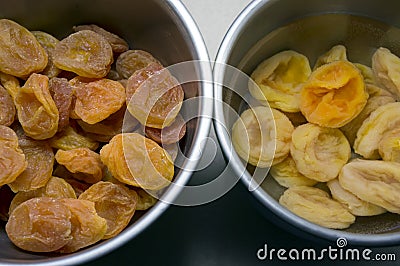 Dried apricots soaked in water in dishes on the table Stock Photo