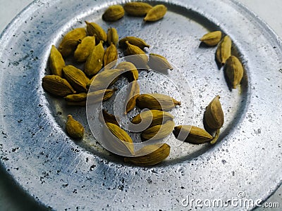 Dried cardamom placed spreaded on a plate. Stock Photo