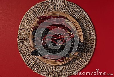 Dried Chilis on wood dish Red background Pasilla and Guajillo mexican spice Stock Photo