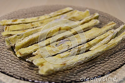 Dried fish straws on a plate on the table. Stock Photo