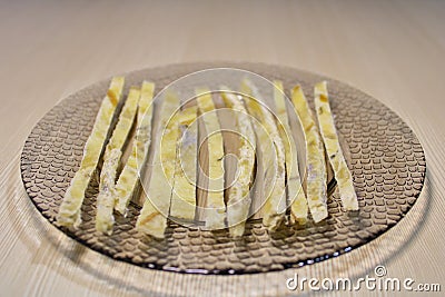 Dried fish straws on a plate on the table. Stock Photo