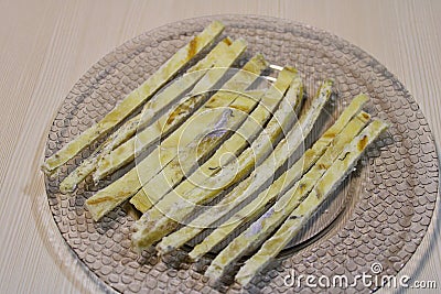 Dried fish straws on a plate on the table. Stock Photo