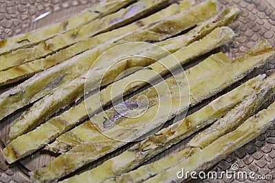 Dried fish straws on a plate on the table. Stock Photo