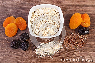 Dried fruits, oat bran, linseed and oatmeal in bowl, increase metabolism Stock Photo
