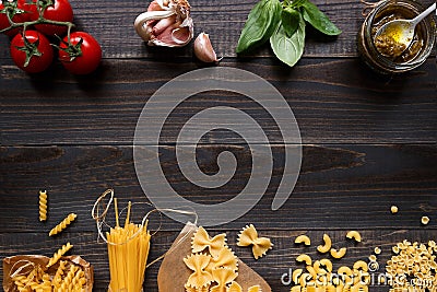 Dried mixed pasta and vegetables on the dark wooden table top view, with copy space Stock Photo