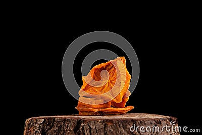 Dried persimmons. Bright orange slices on a dark background. Useful sweets. Ingredients for fruit tea or punch Stock Photo