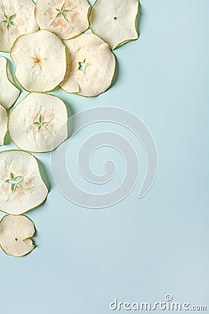 Dried pieces of Apple chips on a blue isolated background. Homemade harvesting, healthy and organic food Stock Photo