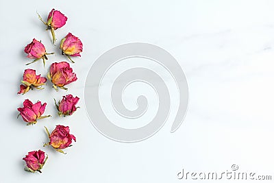 Dried pink roses on a marble background, arranged in a frame on the left side . View from above, flat lay, spase for a text Stock Photo