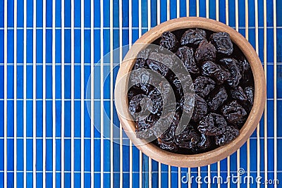 Dried prunes in wooden bowl Stock Photo