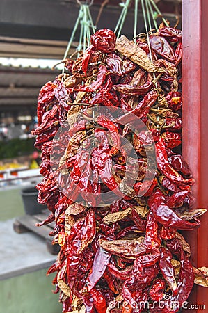 Dried red hot chilly peppers hanging on the market Stock Photo