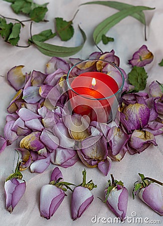 Dried roses, candle and book on a cloth Stock Photo