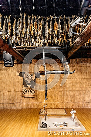 Dried salmons and fireplace inside house of Shiraoi Ainu Village Museum in Hokkaido, Japan Stock Photo