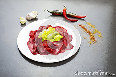 Dried salted bresaola beef thinly sliced on a plate, appetizers plate of Bresaola Stock Photo