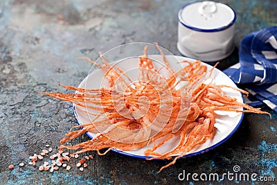 Dried squid tentacles snack with hot spices on a plate Stock Photo