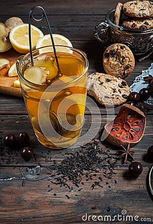 Dried tea with lemon and cookies on wooden table Stock Photo