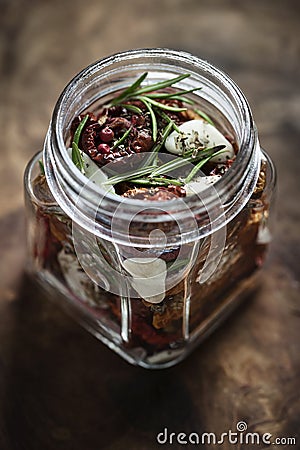 Dried tomatoes in a jar with fresh spices Stock Photo