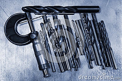 Drill bits and micrometer caliper on metal background Stock Photo