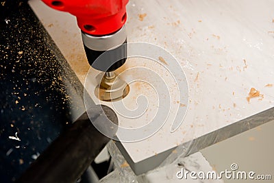 Drilling a hole for a hinge on a furniture door. Selective focus. Close up Stock Photo