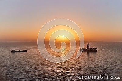 Drilling ship drilling oil well bottom ocean shelf. Geological exploration gas and oil fields in sea at sunset Editorial Stock Photo