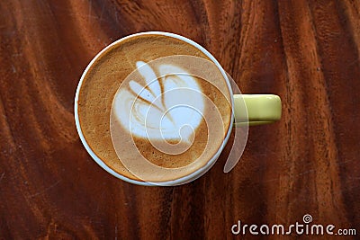 Drink scene of Hot Latt Coffee in yellow Cup on Brown wood Table at Coffee Cafe in Danang Vietnam Stock Photo