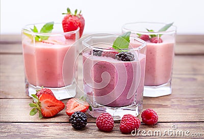 Drink smoothies four summer strawberry, blackberry, kiwi, raspberry on wooden table. Stock Photo