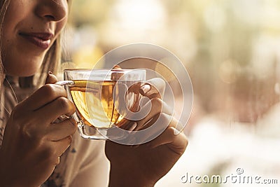 Drink Tea relax cosy photo with blurred background. Female hands holding mug of hot Tea in morning. Young woman relaxing tea cup Stock Photo