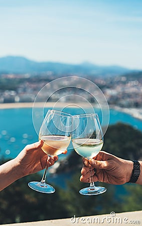 Drink two glasses white wine in friends hands outdoor seascape holidays, romantic couple toast with alcohol, happy people cheering Stock Photo