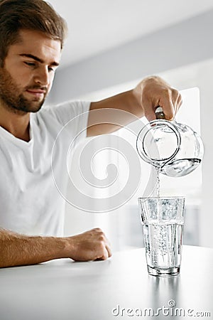 Drink Water. Close Up Man Pouring Water Into Glass. Hydration Stock Photo