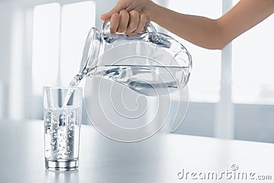 Drink Water. Woman's Hand Pouring Water From Pitcher Into A Glas Stock Photo