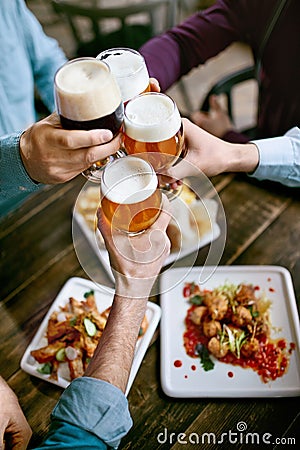 Drinking Beer. Friends Raising Glasses Of Beer Stock Photo