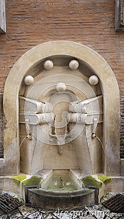 Drinking fountain in a wall in a Roman street Stock Photo