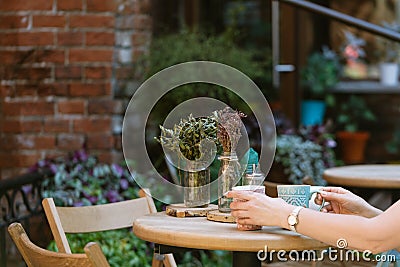 Drinking tea. woman holding cup of beverage while sitting at cafe. Stock Photo