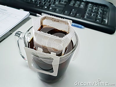 Drip coffee cup with keyboard and notebook. Stock Photo