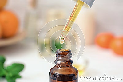 Dripping citrus essential oil into bottle, closeup Stock Photo