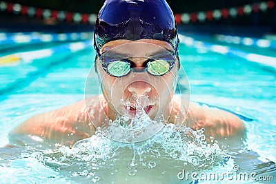 Driven to improve his lap time. Cropped view of a determined male swimmer swimming laps. Stock Photo