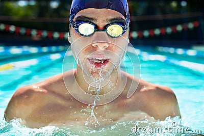 Driven to improve his lap time. Cropped view of a determined male swimmer swimming laps. Stock Photo