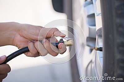 Driver checking air pressure and filling air in the tires Stock Photo
